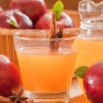 aepfel im korb und apfelsaft in glaesern